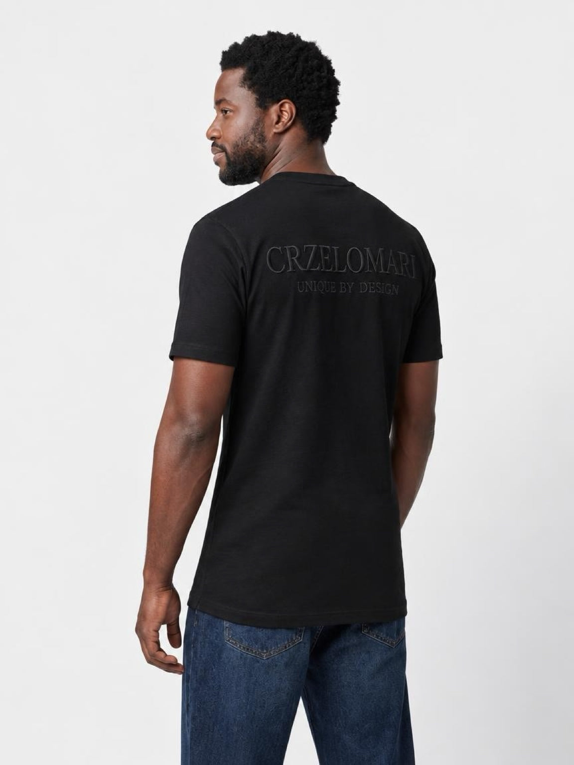 Back view of The Founders Tee in black on a tall man, athletic fit with extended length