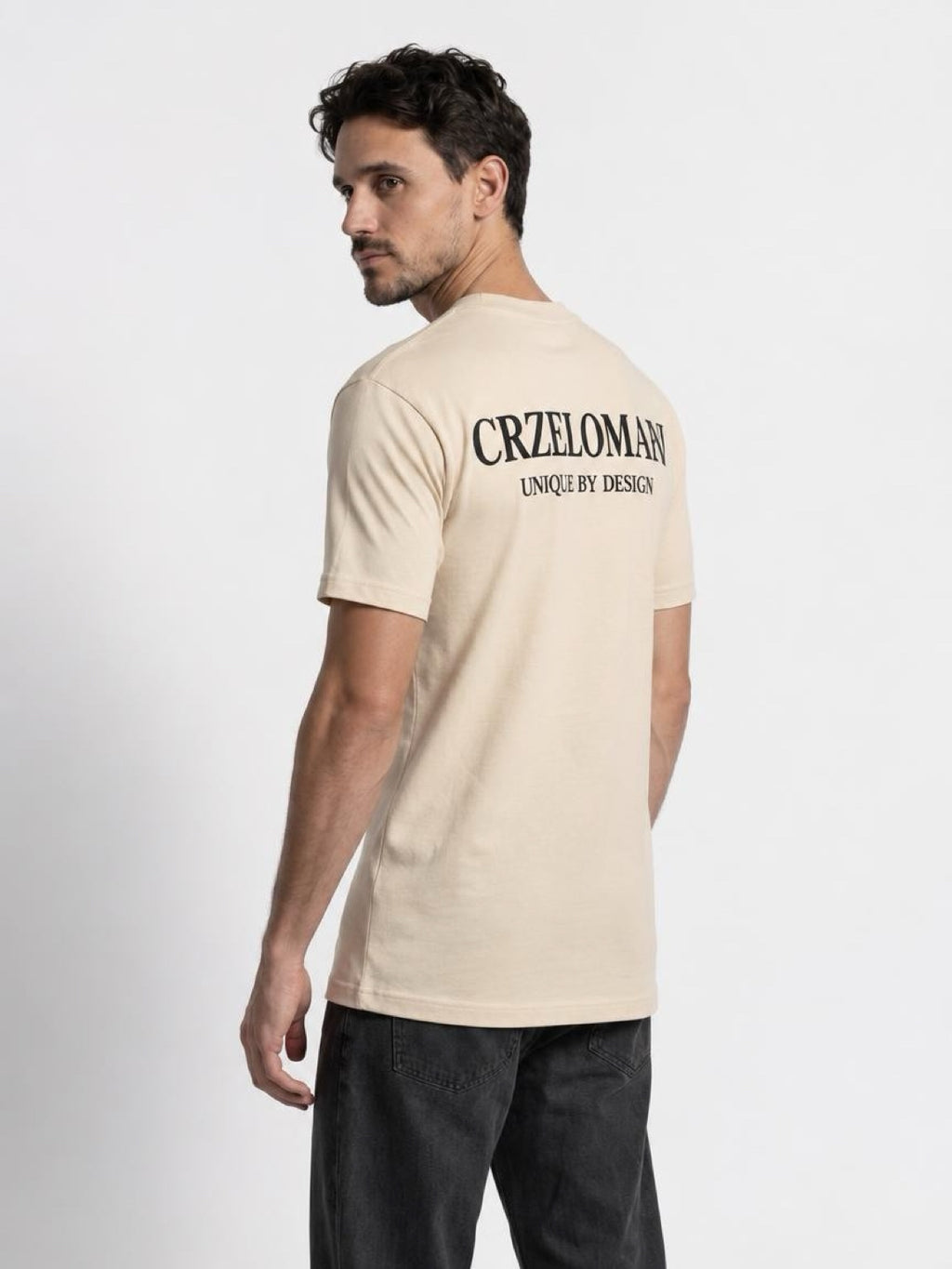 Back view of The Founders Tee in cream on a tall man, showing the CRZELOMARI back print