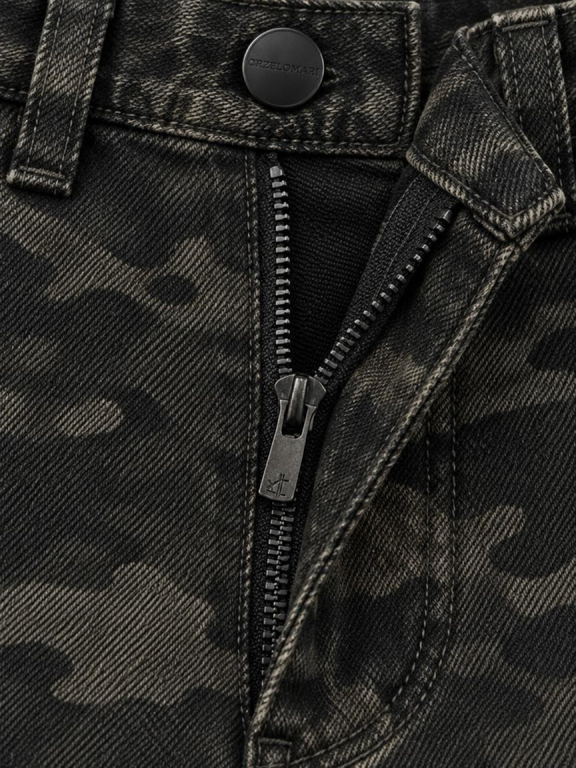 Close-up of the zip fly and matte black hardware on camo cotton denim cargo shorts
