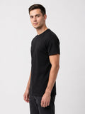 Tall athletic man wearing the CRZELOMARI By Design Tee in black, relaxed fit with extended length