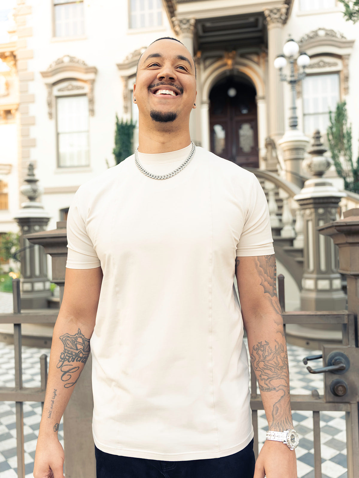 Tall man smiling in the cream Founders Tee, an athletic fit tall te