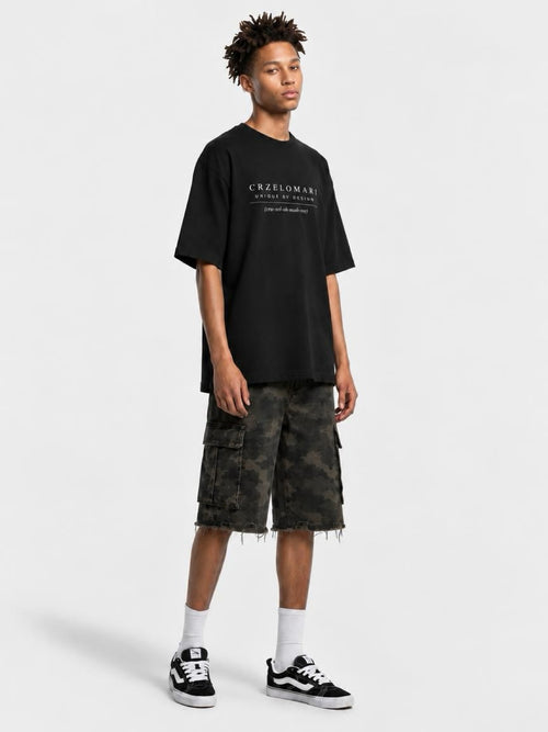 Tall man wearing CRZELOMARI Field Camo Cargo Shorts with a 14" inseam and a black tee, full-length view