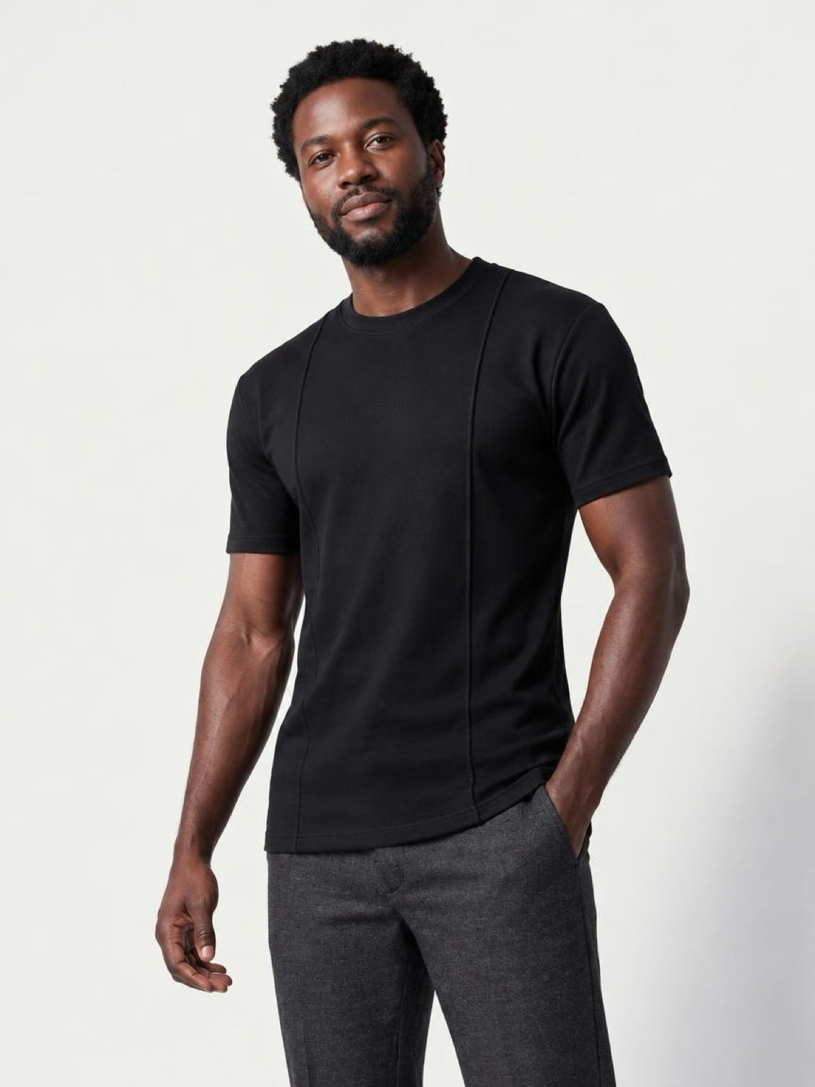The Founders Tee in black, side angle showing the longer body length on a tall athletic build